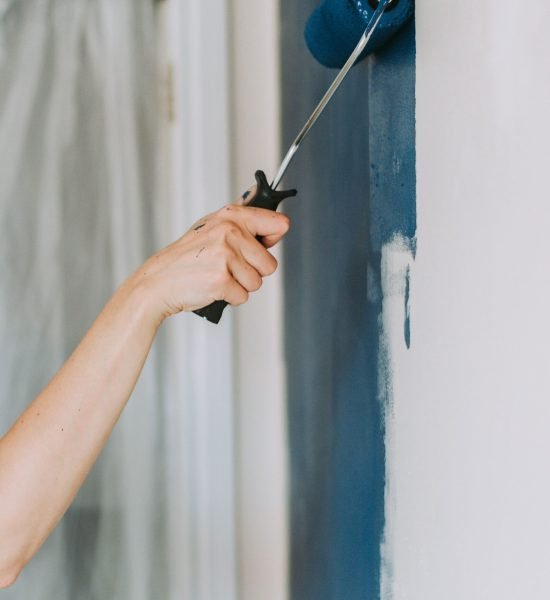 closeup-shot-person-using-paint-rollers-with-color-blue